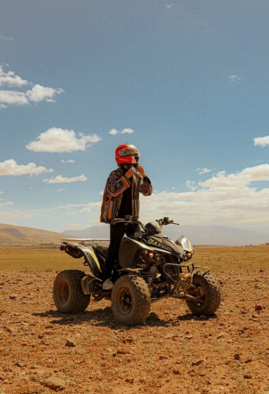 Happy travelers riding quad bikes in the Agafay Desert with Oasis Sky near Marrakech during an exciting desert adventure.