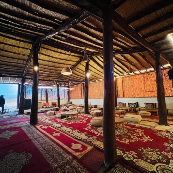 Client enjoying breathtaking sunset over Agafay Desert at Agafay Oasis Sky in Marrakech, with golden skies and desert views.