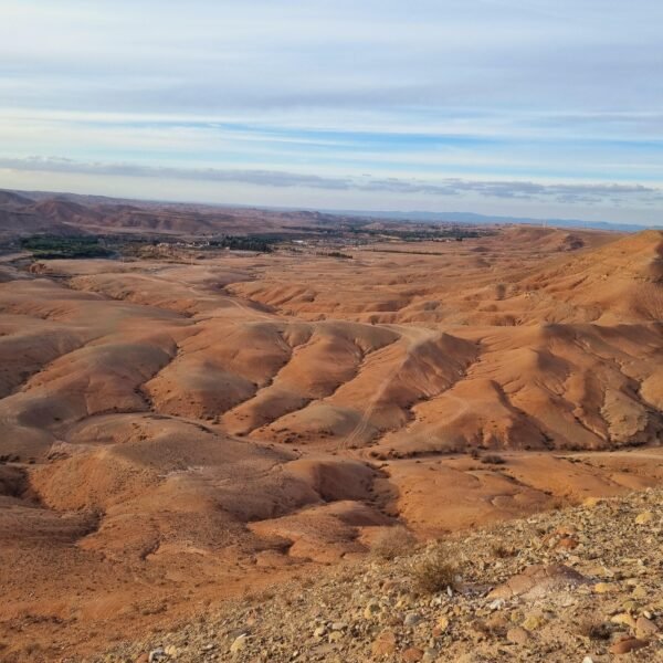 Client enjoying breathtaking sunset over Agafay Desert at Agafay Oasis Sky in Marrakech, with golden skies and desert views.