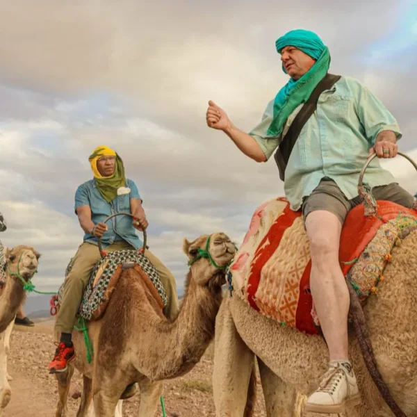 Agafay Desert Marrakech Tours Tourists riding camels across the Agafay Desert landscape near Marrakech Morocco