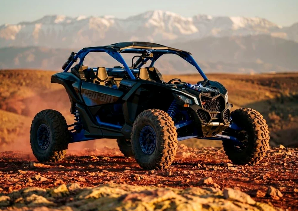 Blue Can-Am off-road buggy with Atlas Mountains in the background near Agafay Desert, featured for the Oasis Sky buggy, pool and dinner package