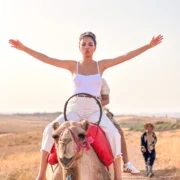 Traveler enjoying a guided camel ride at sunset in Agafay Desert near Marrakech
