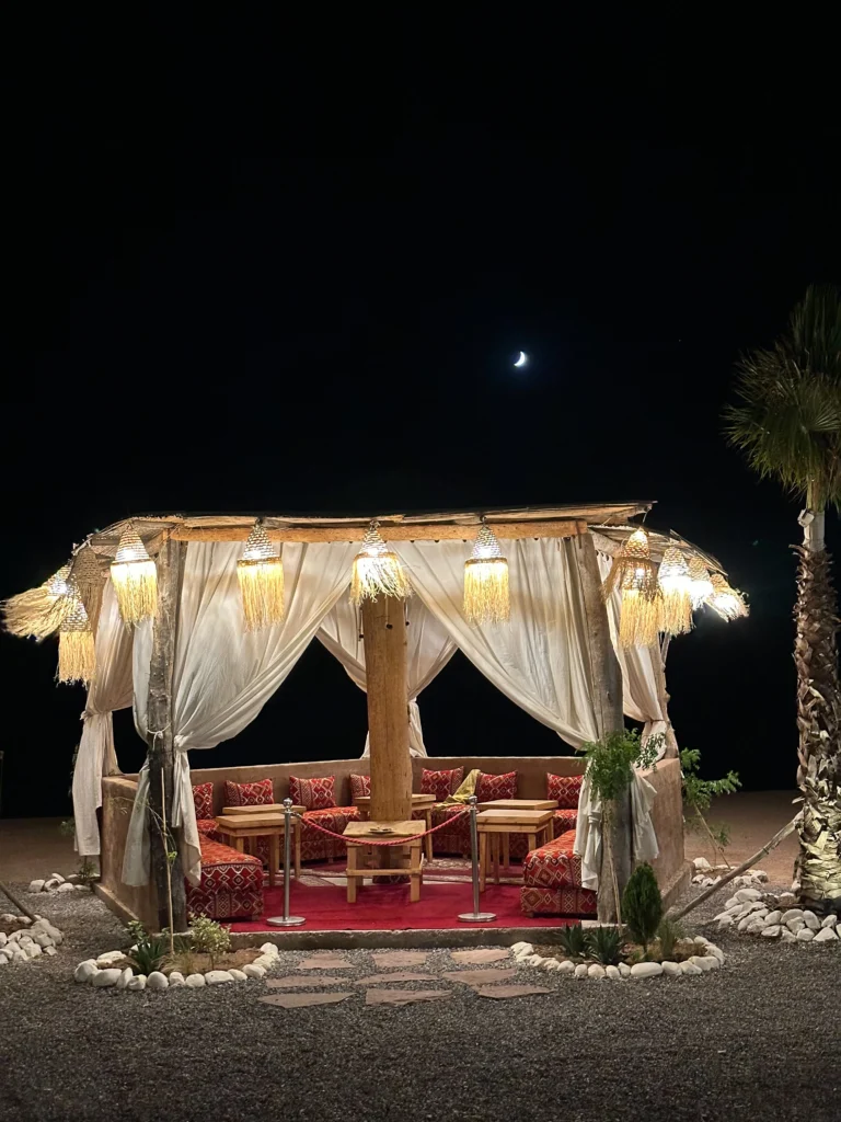 Lantern-lit Moroccan dinner setting beneath the stars at an Agafay Desert camp near Marrakech
