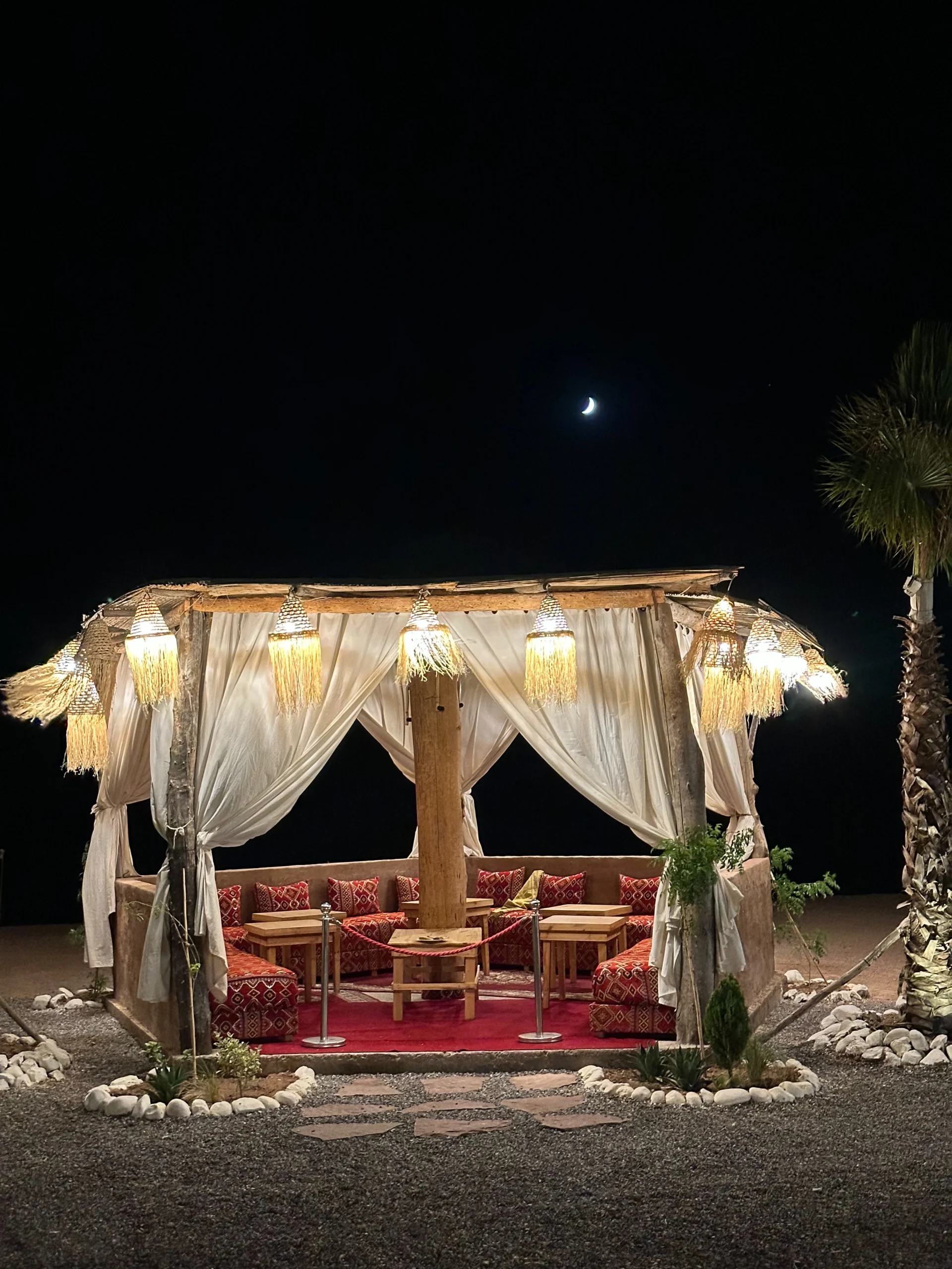 Illuminated desert dining tent at night in the Agafay Desert near Marrakech