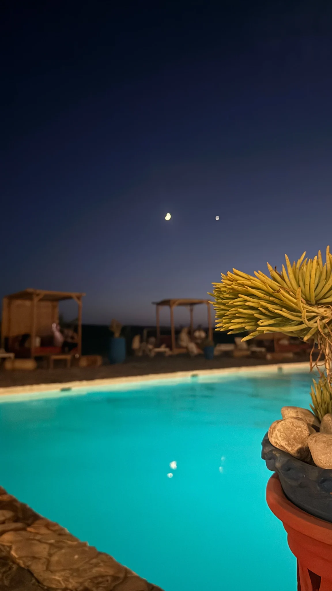 Illuminated swimming pool at night at an Agafay Desert camp near Marrakech