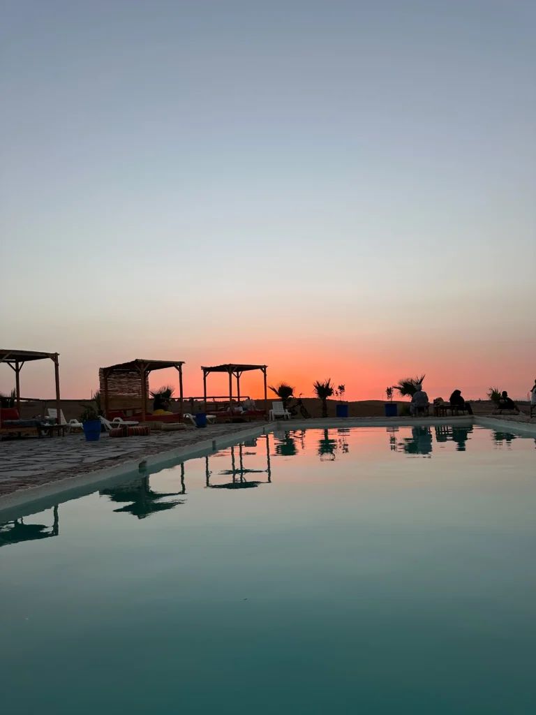 Oasis Sky swimming pool at sunset in Agafay Desert with hills near Marrakech