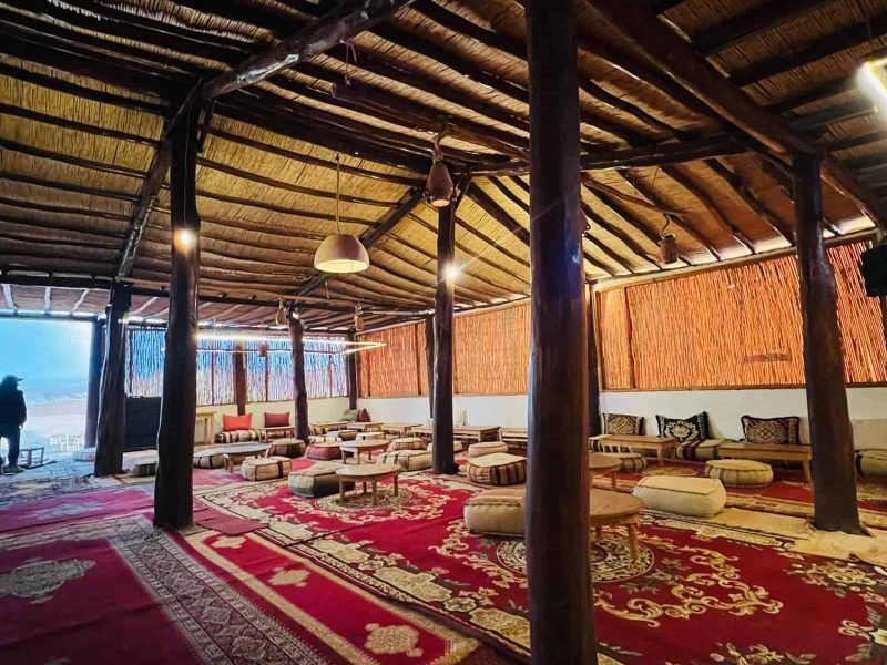 Client enjoying breathtaking sunset over Agafay Desert at Agafay Oasis Sky in Marrakech, with golden skies and desert views.