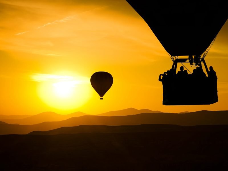 Hot balloon silhouette with sunrise sky background.