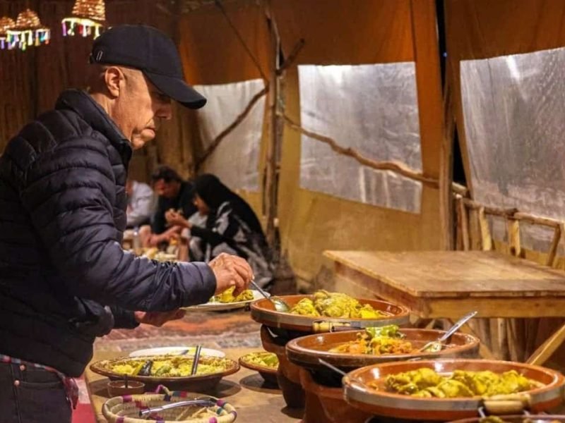 Tourists taking photos during camel ride in Agafay Desert near Marrakech